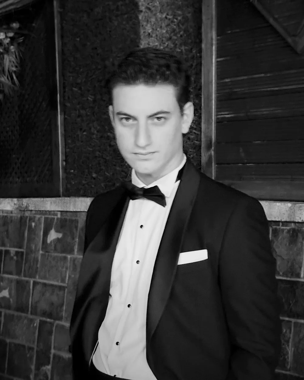 Portrait of Batuhan Emre TAMAM, Founder and CEO of OXS Corp, in black tie.